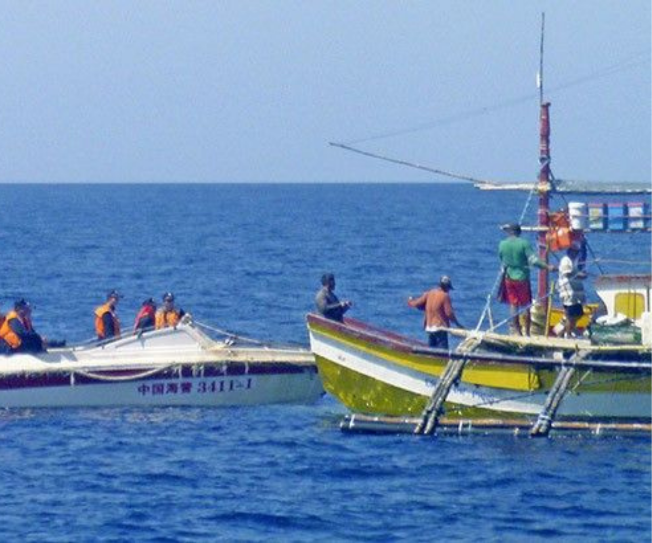 Fisherfolk on a boat beside a Chinese vessel on the West Philippine Sea (Viray, 2018)